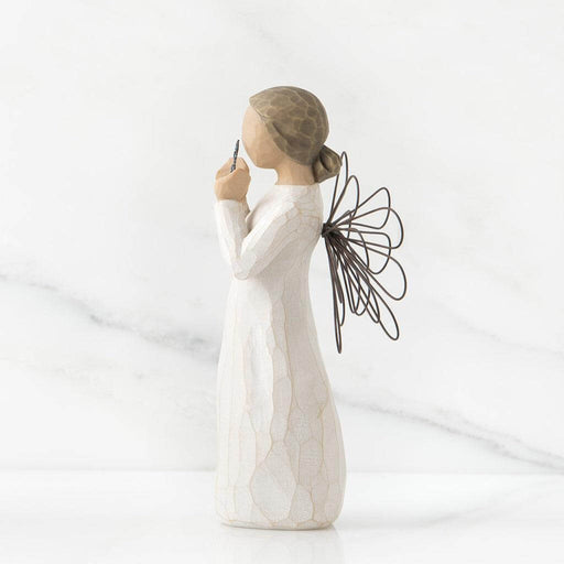 White figurine of a woman holding an star  with wings on a white background