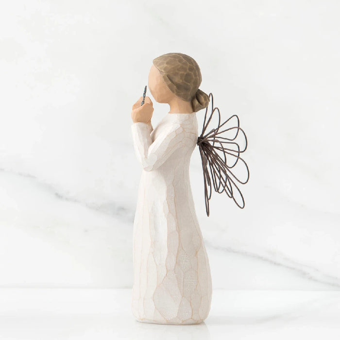 A willow tree angel with a heart, embodying themes of love and peace in a natural environment.