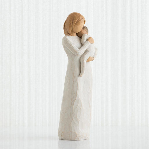 Statue of a mother embracing her child against a white background