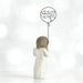 Statue of a woman holding a balloon with 'miss you' written on it against a white background