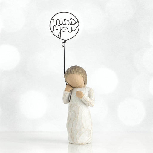 Decorative figure holding a balloon with 'miss you' text on a white background