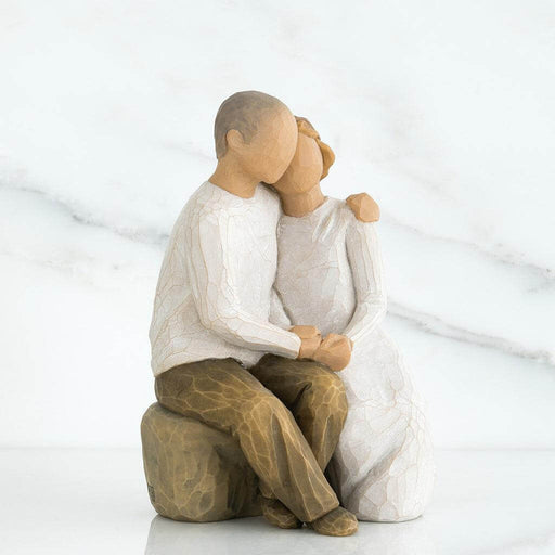  figurine of a couple embracing on a white background