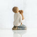Figurine of a child holding a dog on a white background