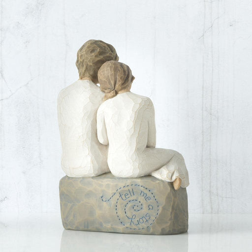 Statue of a grandmother and granddaughter  sitting together with 'tell me a lullaby' text on a white background