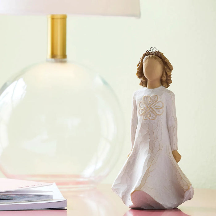 Decorative angel figurine with a white dress and crown on a light background