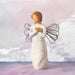 Decorative angel figurine with floral patterns against a soft, blurred background