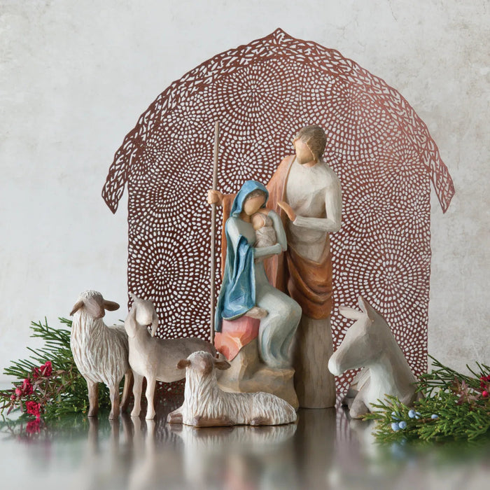 Nativity scene with Mary, Joseph, and baby Jesus under a patterned canopy.