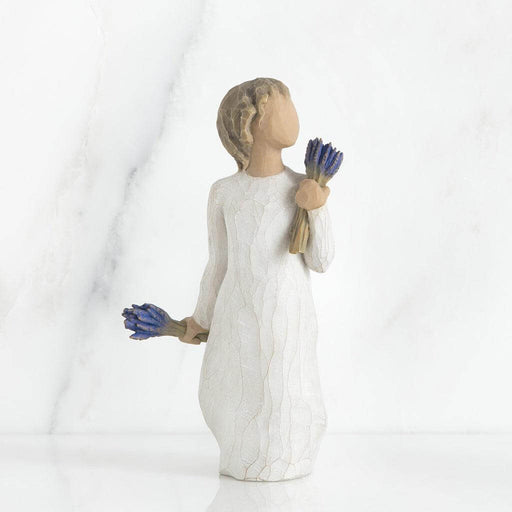 Statue of a woman holding blue flowers on a white background