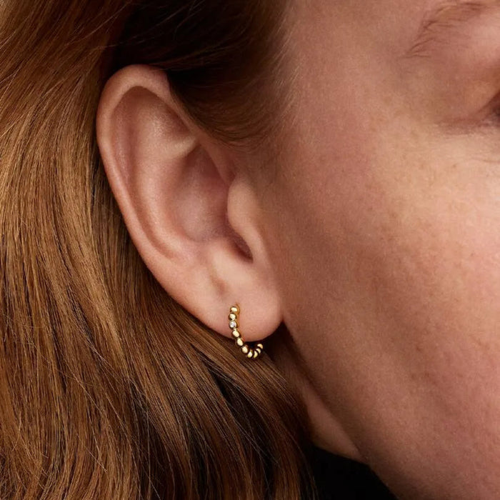 PANDORA Beaded Huggie Earrings in 14k gold plating with delicate bead detailing and a sparkling center stone