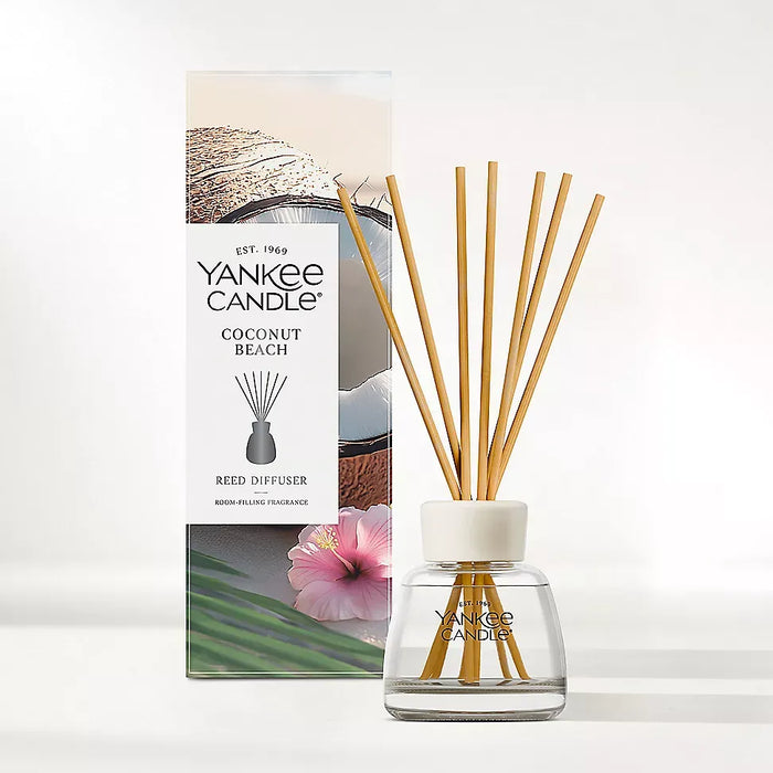 The Yankee Candle Coconut Beach Reed Diffuser Kit is a fruity, tropical home fragrance diffuser. It features salty air, pineapple, fresh coconut, lei blossom, musk, and Tahitian vanilla notes. The starter kit contains a 3.38-fluid-ounce pre-filled glass diffuser and reed sticks. It provides continuous, flame-free home fragrance for up to eight weeks.