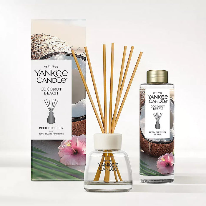 Yankee Candle Coconut Beach reed diffuser set including a glass bottle with a gold cap, natural reed sticks, and the branded retail box on a clean white background.