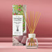 Yankee Candle Home Sweet Home reed diffuser with natural wood reeds in a clear glass bottle, shown next to its printed packaging box on a pink background.