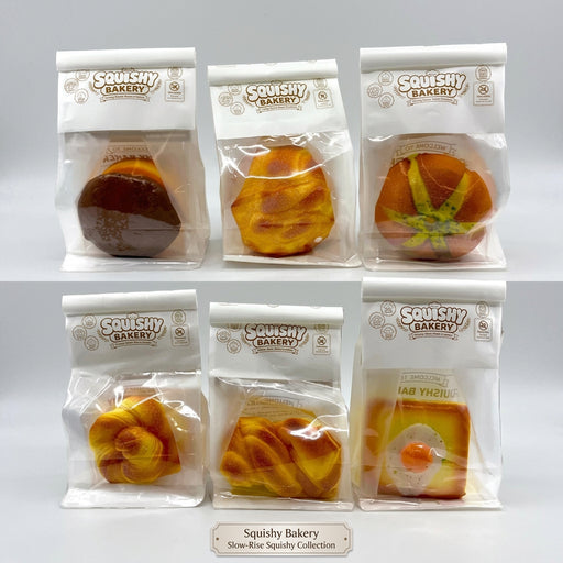 Six packaged squishy toy breads and pastries arranged in a 2x3 grid on a plain white background. Each item is sealed in a clear plastic bag with a white header card printed with the brand name 'Squishy Bakery'.