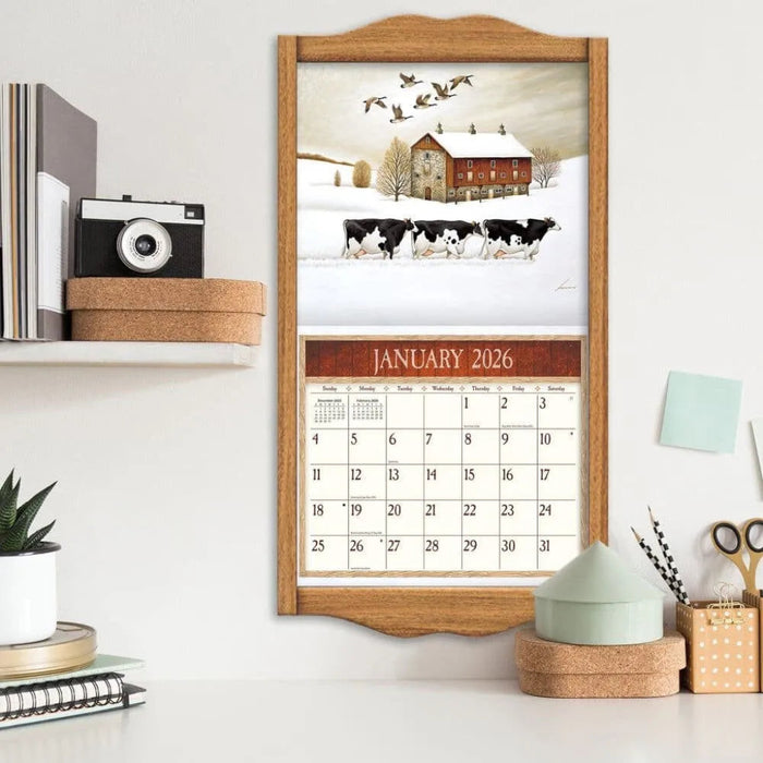 Calendar with a winter scene and January 2026 on a shelf with decorative items.