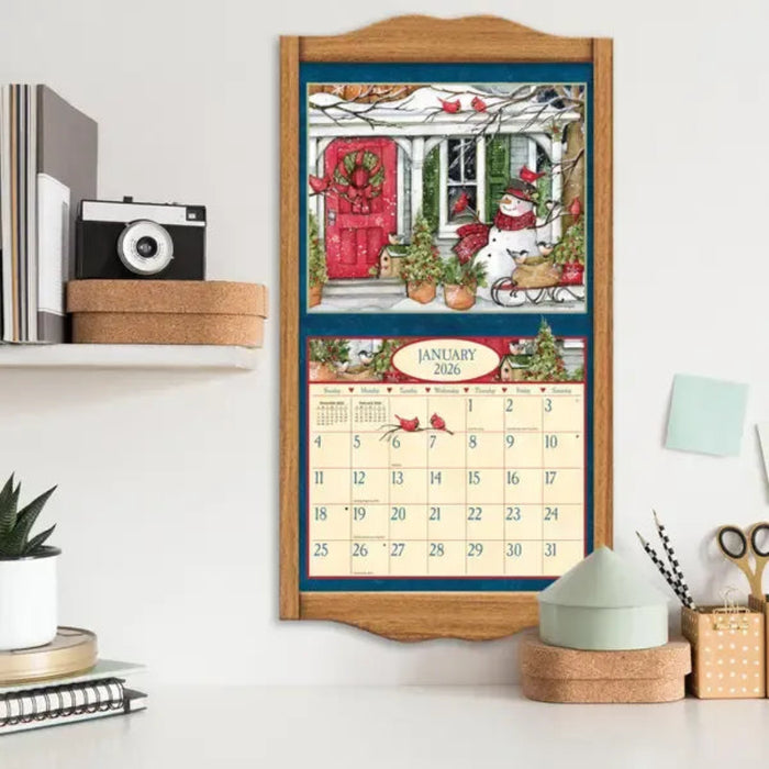 Calendar with Christmas design on a wooden frame, displayed on a shelf.