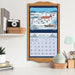 Calendar with winter scene design on a wall above a desk