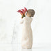Decorative figurine of a woman holding flowers against a white background