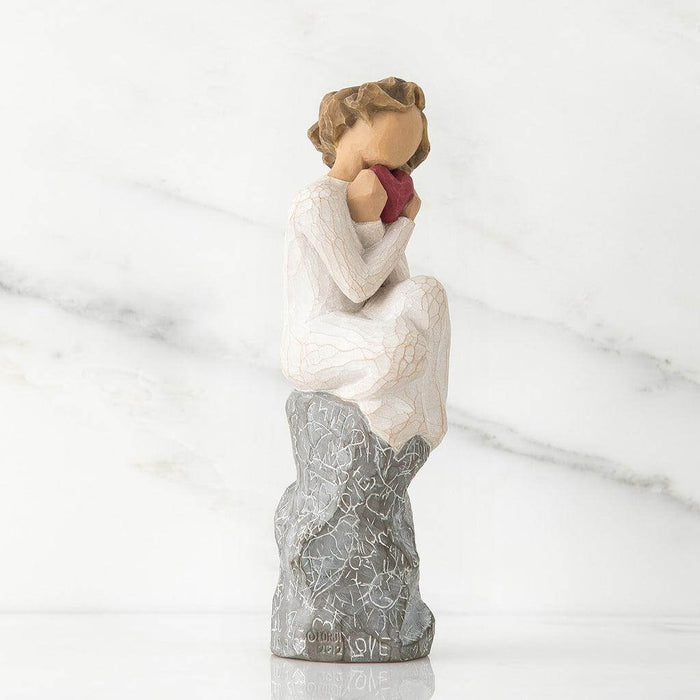 Statue of a woman holding a heart with a marble background