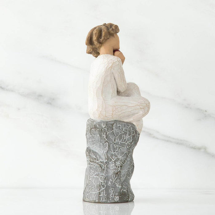 Statue of a woman sitting on a rock with a marble background