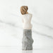 Ceramic sculpture of a  figure with textured surface on a marble background