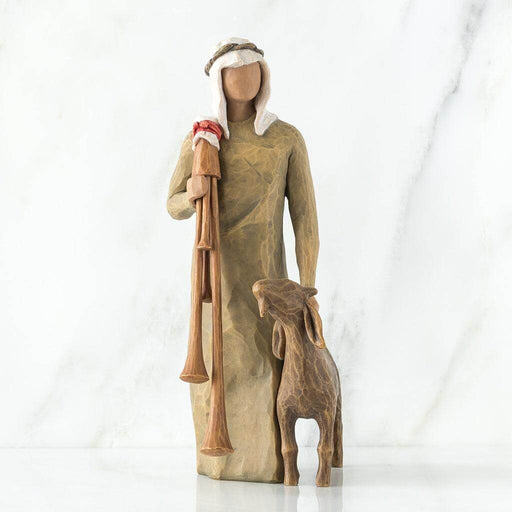 Wooden sculpture of a shepherd with a lamb on a white background