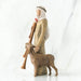 Wooden nativity scene figure of a shepherd with a lamb on a white background
