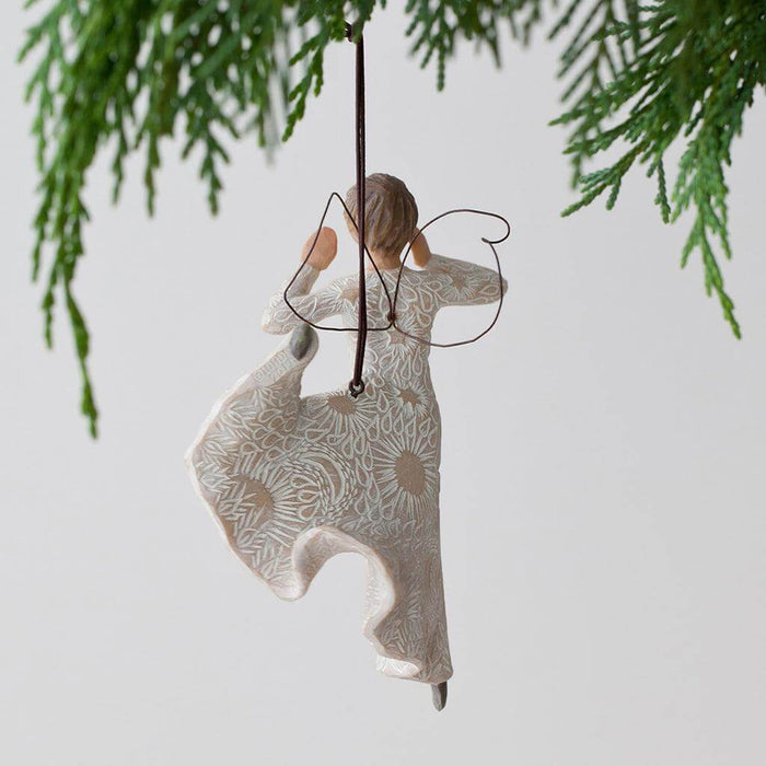 Decorative ornament of a woman with wings hanging from a tree branch.