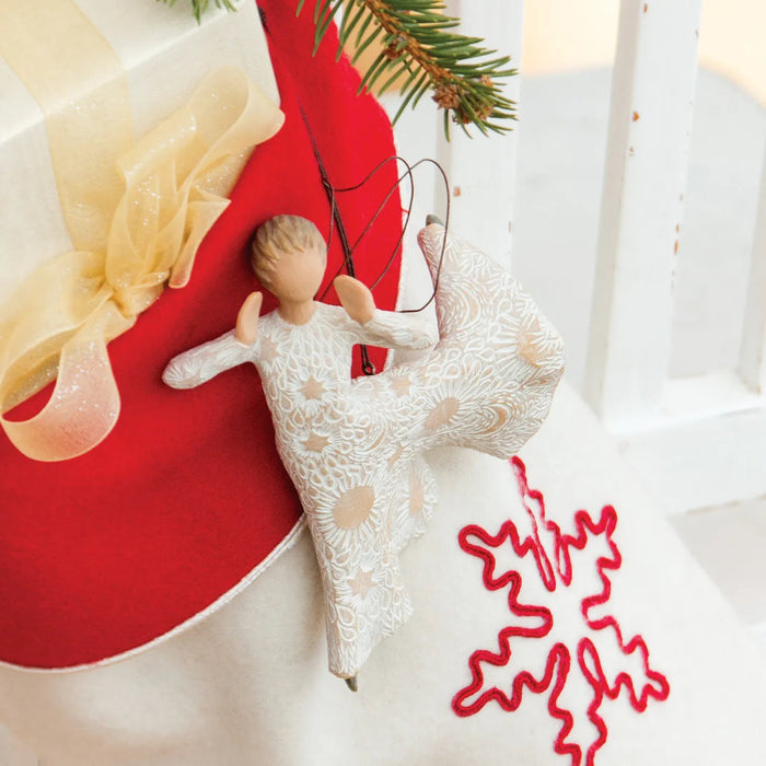 Decorative angel figurine with red heart and yellow ribbon on a white surface
