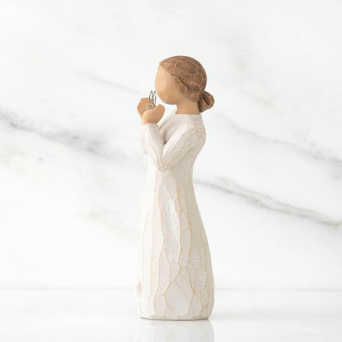 White  figurine of a woman holding a heart on a white background