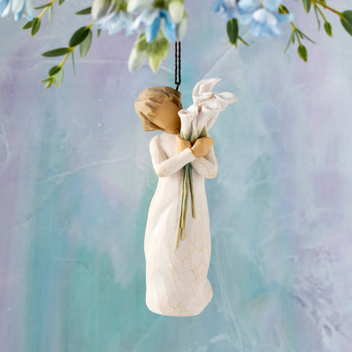 Decorative angel figurine holding flowers against a soft, multicolored background