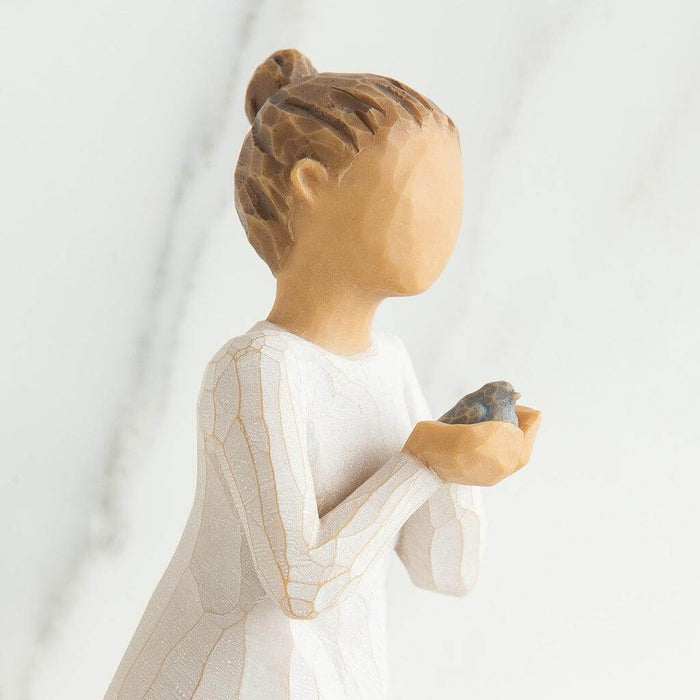 Statue of a woman holding a bird against a white background