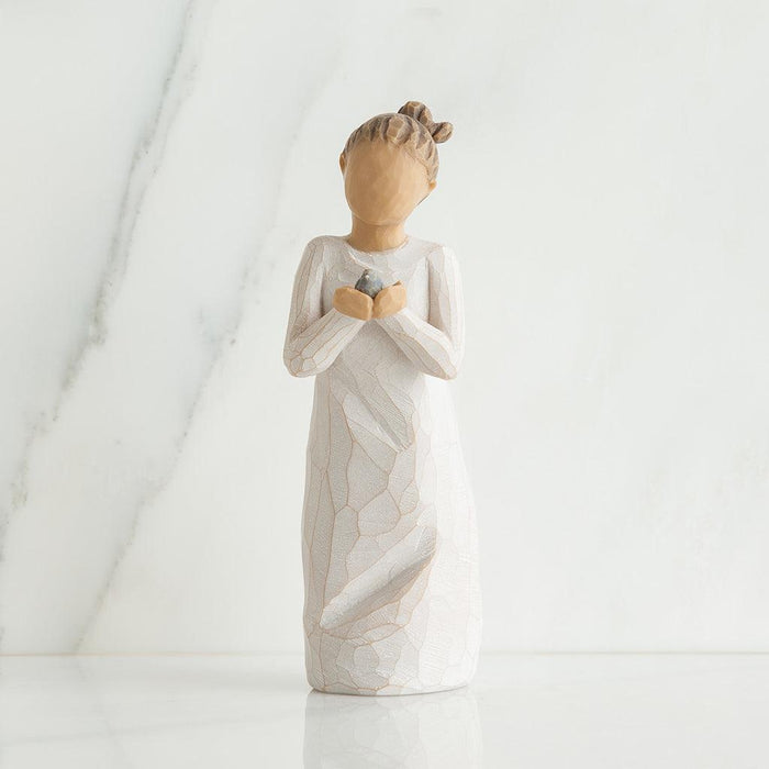 Decorative angel figurine holding a baby bird  on a white background