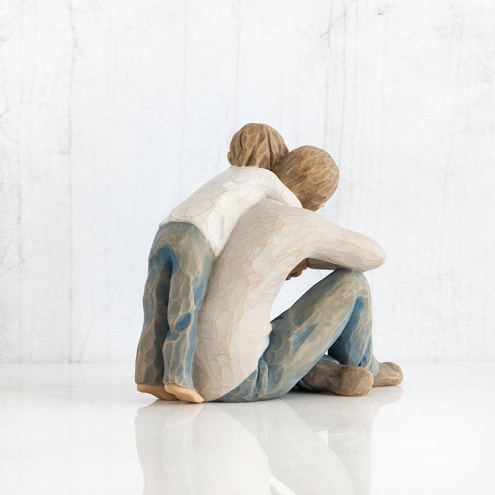 Statue of father and son embracing on a white background