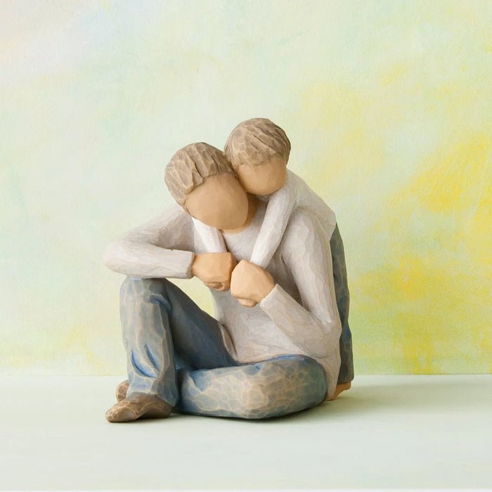 Father and child  sitting close together against a soft, multicolored background