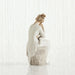Statue of woman sitting with a child in her lap on a textured white surface