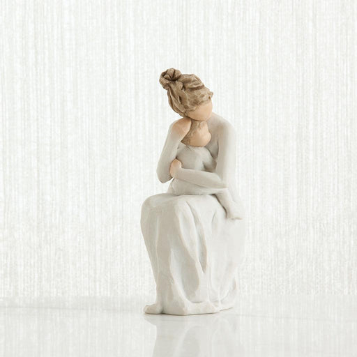 White ceramic figurine of a woman sitting with her hand on her face against a white background