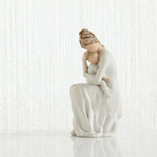 White ceramic figurine of a woman sitting with her child on a white background