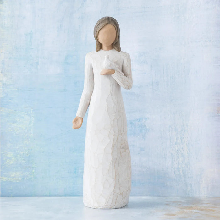White figurine of a woman holding a Dove  against a light blue background