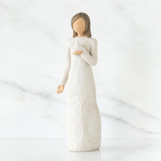 White ceramic figurine of a woman in a long dress with a white dove in her hand  on a white background