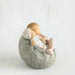 Small figurine of a baby sitting on a stone-like surface against a white background