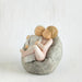 Small figurine of a children embracing on a textured surface