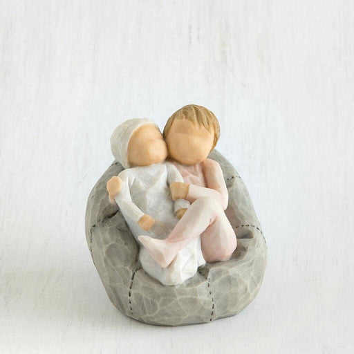 Figurine of two children  embracing on a stone base against a white background