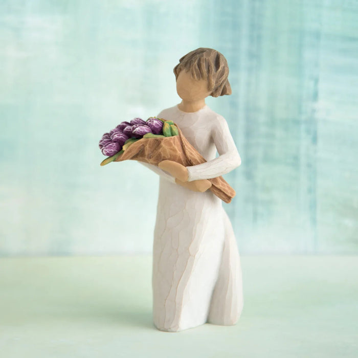 Hand-painted Willow Tree Surprise sculpture with purple bouquet on a blue background 