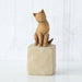  cat figurine on a stone base against a white background