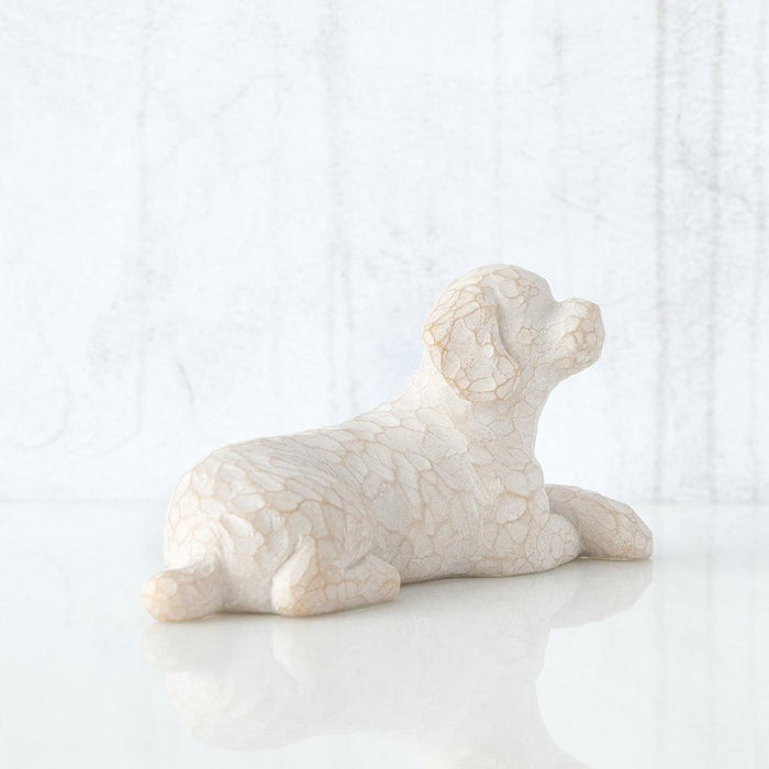 White sculpture of a lying dog on a white background