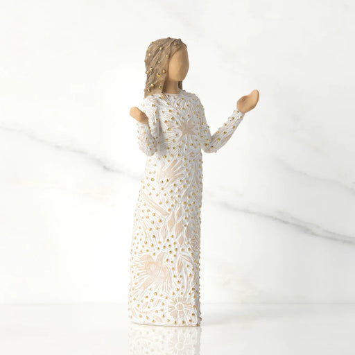 figurine  of a woman in a white dress with gold detailing on a white background