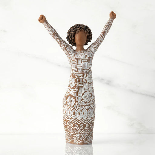 A figurine of a woman with her arms raised, expressing joy or celebration.