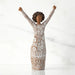 A figurine of a woman with her arms raised, expressing joy or celebration.