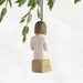 An ornament featuring a girl reading beneath a willow tree, capturing a peaceful and enchanting moment in nature.