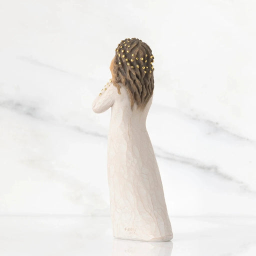 A figurine of a woman elegantly dressed in a flowing white gown, showcasing intricate details and graceful posture.